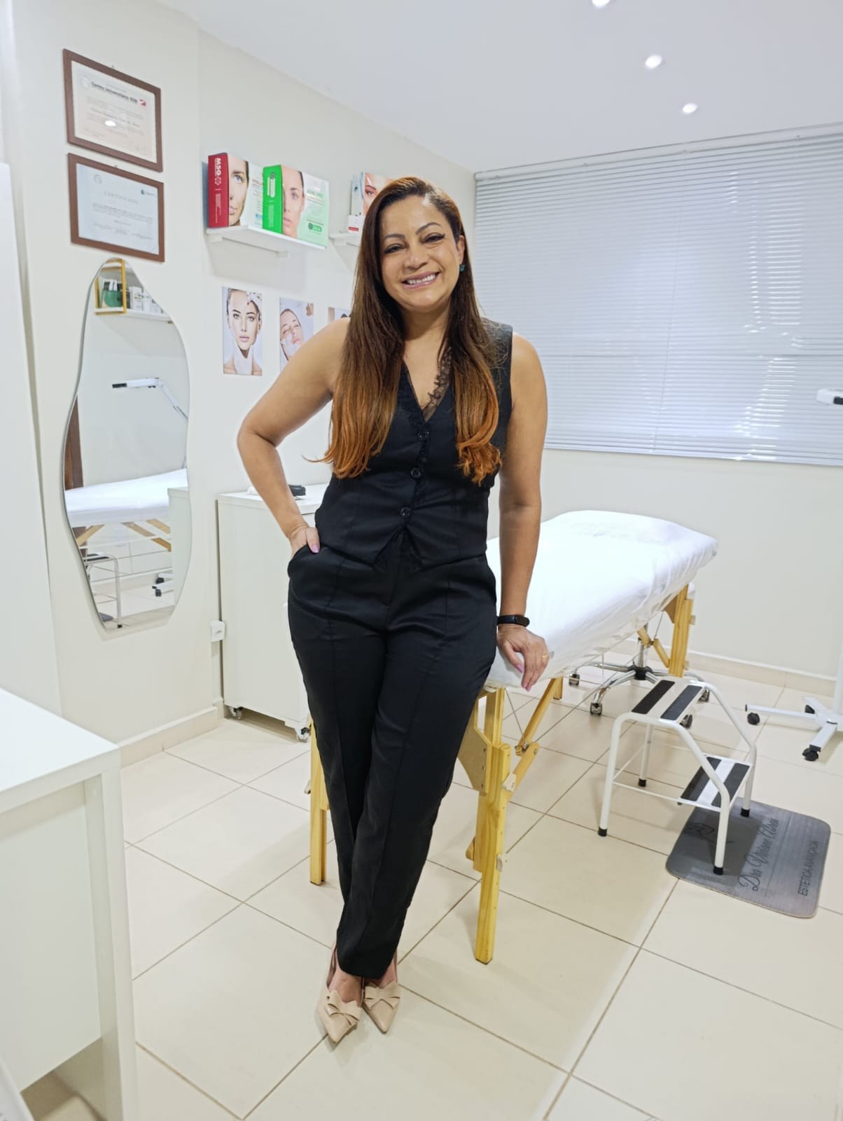 Dra. Viviane Abreu sorrindo na sala de procedimentos do consultório